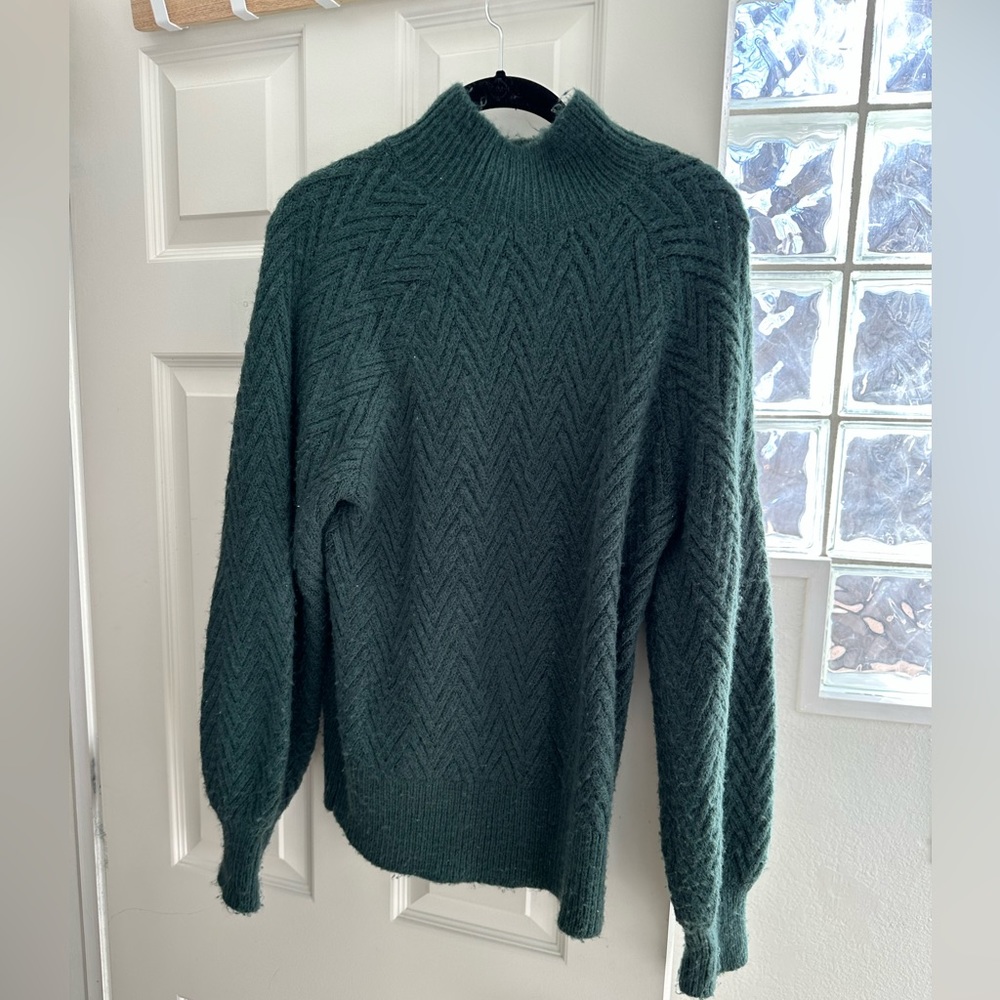 Dark green puff sleeve sweater in good condition with slight piling.